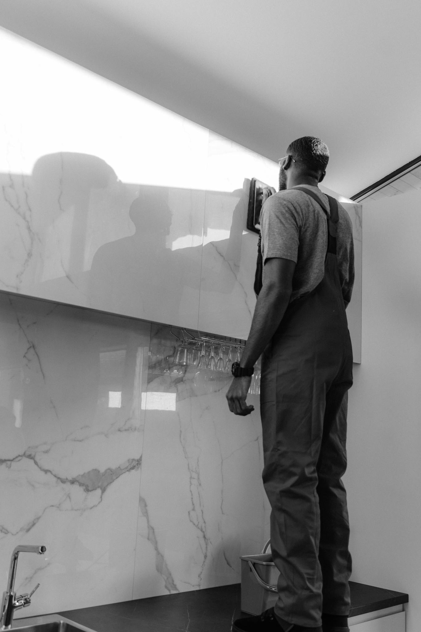 A person professionally cleaning a glass surface in a stylish home interior.